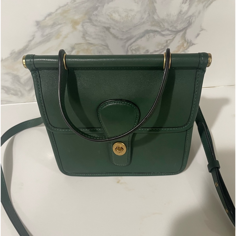 Coach leather top handle bag , turn lock closure , interior pockets . Green